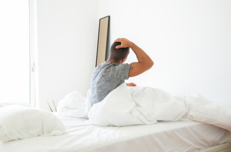 Man waking up with a sore neck from a old pillow